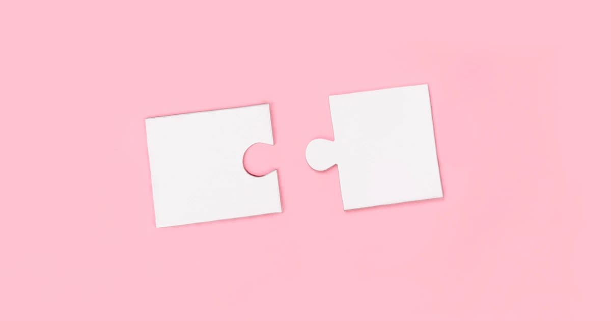 Two puzzle pieces on pink background