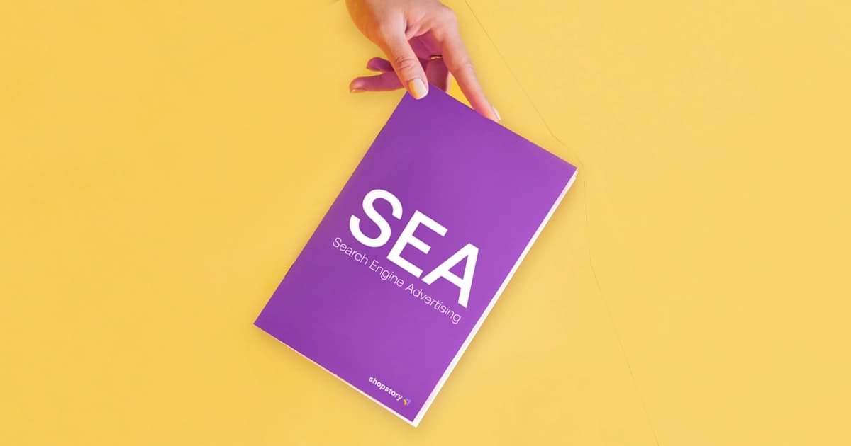 Hand holding a purple SEA guide for marketing beginners