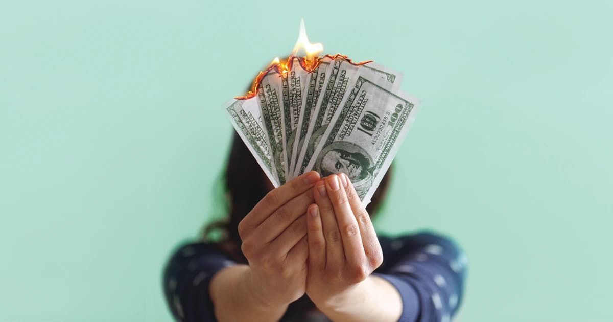 Person holding money that is on fire