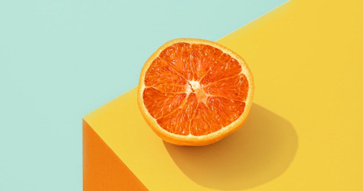 Orange auf einem gelben Tisch mit grünem Hintergrund